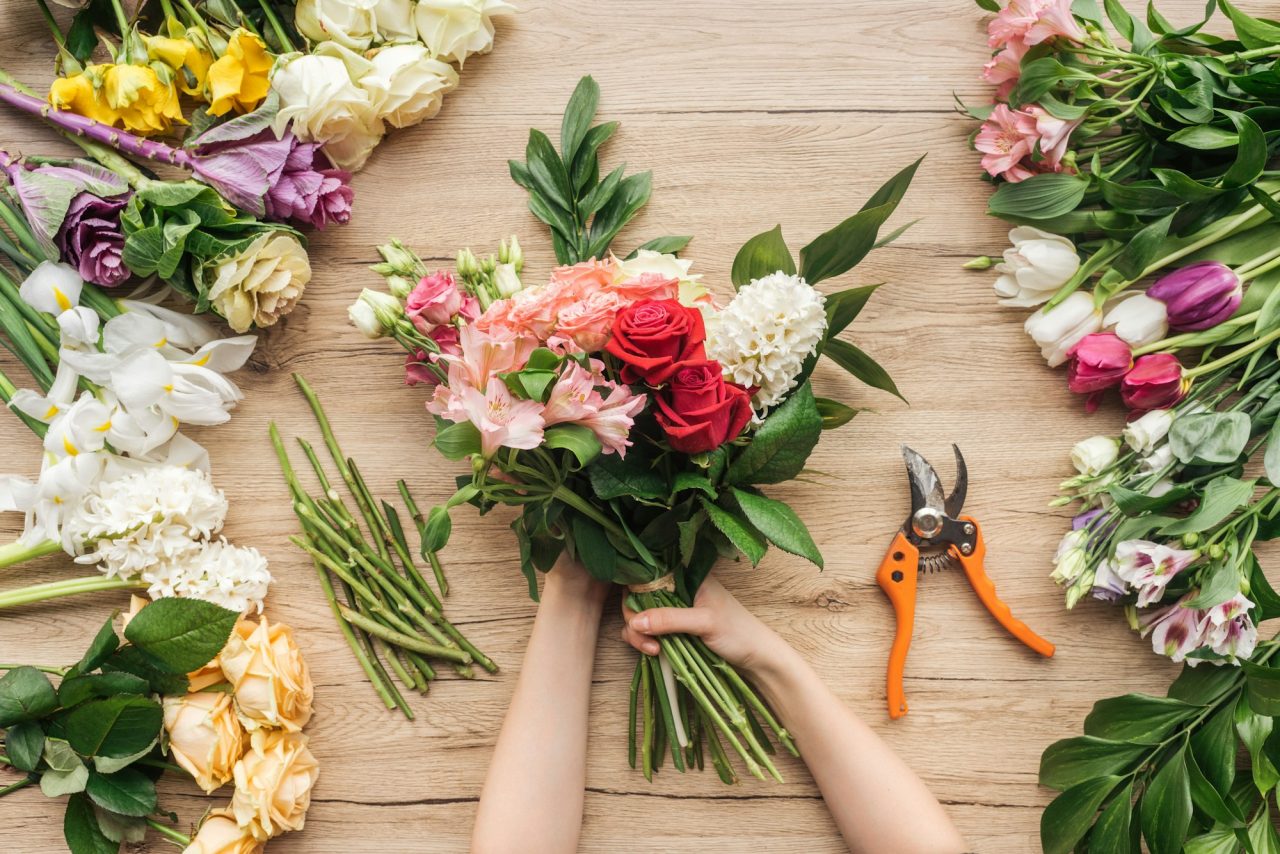 cropped-view-of-florist-holding-flower-bouquet-on-wooden-table.jpg